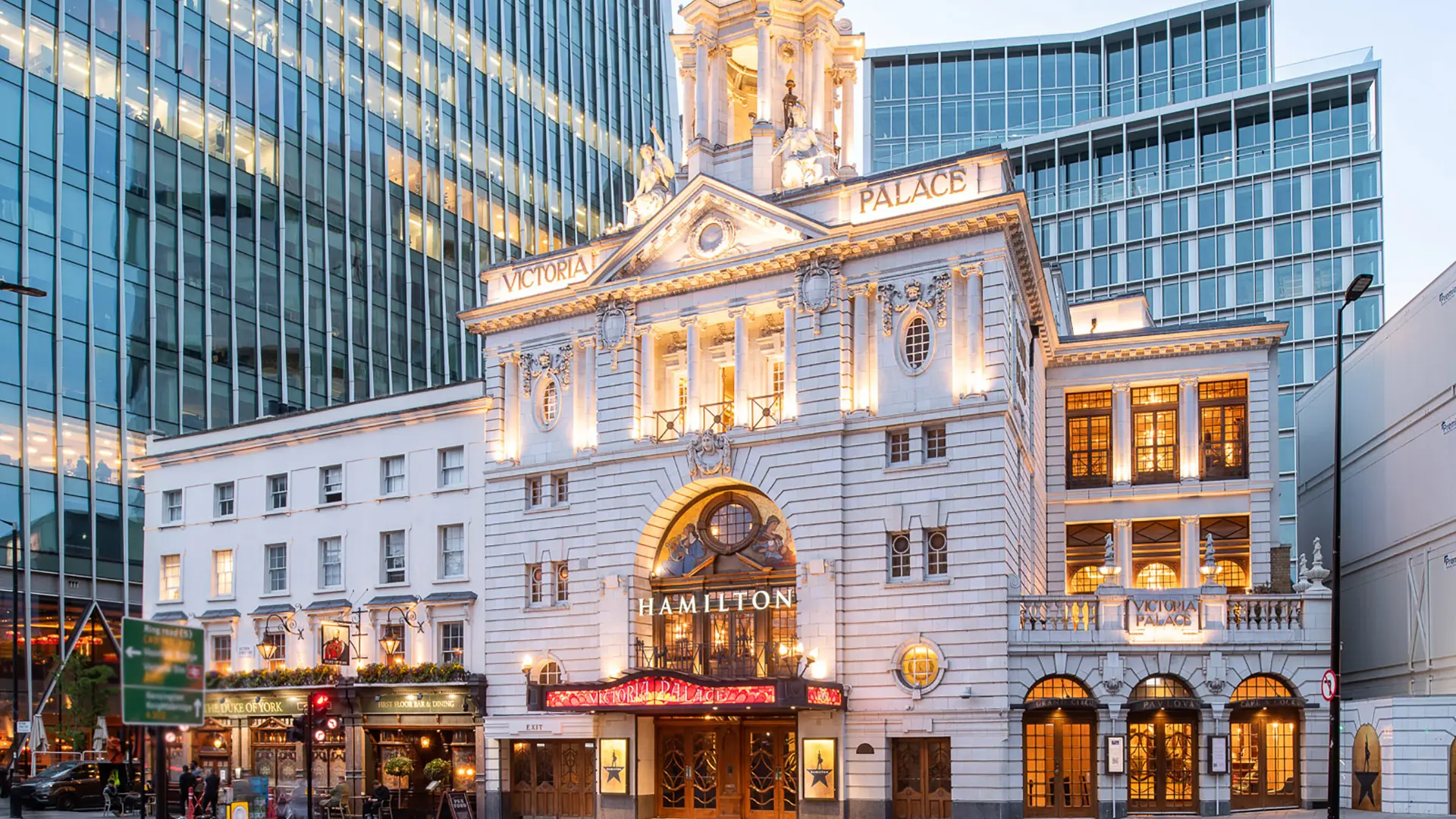 Victoria Palace Theatre external view with their lights on